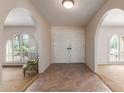 Bright entryway showcasing arched doorways, tile flooring, and double front doors at 14828 N Skokie Ct, Phoenix, AZ 85022