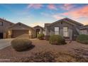 Inviting home exterior featuring desert landscaping, a tidy lawn, and a neutral color palette at 15564 W Mescal St, Surprise, AZ 85379