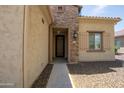 Close up view of the front entry with stone accents, decorative iron door, and address plaque at 16913 W Holly St, Goodyear, AZ 85395