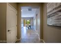 Hallway view leading to a dining area, with tile flooring and neutral paint at 16913 W Holly St, Goodyear, AZ 85395