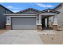 Charming exterior elevation featuring a two-car garage, desert landscaping, and inviting front porch at 17290 W Daley Ln, Surprise, AZ 85387
