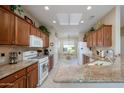 Well-lit kitchen boasts granite countertops, wood cabinets, and modern appliances at 21003 N Circle Cliffs Dr, Surprise, AZ 85387
