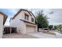 Home exterior featuring an attached two-car garage, stucco finish, and mature trees in a well-maintained neighborhood at 231 N Nash Way, Chandler, AZ 85225