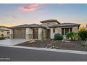 Beautiful home featuring a three-car garage, stone accents, and desert landscaping at 3020 N 165Th Ave, Goodyear, AZ 85395