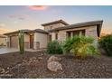Beautiful home featuring a three-car garage, stone accents, and desert landscaping at 3020 N 165Th Ave, Goodyear, AZ 85395