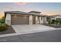 Beautiful home featuring a three-car garage, stone accents, and desert landscaping at 3020 N 165Th Ave, Goodyear, AZ 85395