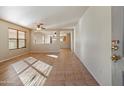 Open-concept living room with tile flooring, ceiling fan, and natural light from large windows at 3027 W Red Fox Rd, Phoenix, AZ 85083