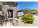 Beautiful home featuring an arched entry and wrought iron gate, plus desert landscaping at 30434 N Palo Brea Dr, Scottsdale, AZ 85266