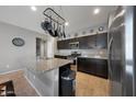 Open kitchen with stainless steel appliances, granite countertops and pot rack above the island at 31006 W Weldon Ave, Buckeye, AZ 85396