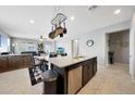 Open concept kitchen flows into the living area, featuring an island with a stainless steel dishwasher at 31006 W Weldon Ave, Buckeye, AZ 85396