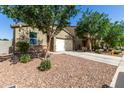 Single-story home with desert landscaping, mature shade trees and an attached two-car garage at 36203 N Urika Dr, San Tan Valley, AZ 85140