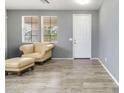 Inviting living room featuring neutral tones, two windows, and an elegant tan leather chair at 46185 W Dutchman Dr, Maricopa, AZ 85139