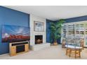 Cozy living room featuring a white brick fireplace, large windows with shutters, and comfortable seating at 4711 S Los Feliz Dr, Tempe, AZ 85282
