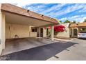 Covered carport with space for two cars with a colorful bougainvillea in the background at 5208 S Deborah Dr, Tempe, AZ 85283