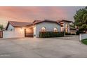 Lovely single Gathering home with a three-car garage and lovely flowering bushes beneath bright windows at 5602 W Alameda Rd, Glendale, AZ 85310