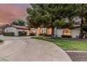 Expansive home with a circular driveway, mature landscaping, and a well-maintained lawn at 5602 W Alameda Rd, Glendale, AZ 85310