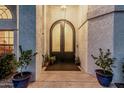 Arched double doors enhance the charm of this home's entry, flanked by potted plants at 5602 W Alameda Rd, Glendale, AZ 85310