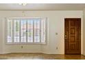 Bright entryway featuring a bay window with shutter and a solid wood door at 5852 E Enrose St, Mesa, AZ 85205