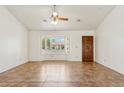 Open living room featuring tile flooring, a ceiling fan, and a bay window with shutters at 5852 E Enrose St, Mesa, AZ 85205
