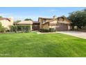Well-maintained home boasting a lush green lawn, mature landscaping, and a cozy covered patio at 6101 W Grandview Rd, Glendale, AZ 85306