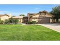 Charming two-story home with well-manicured lawn, mature trees, and a welcoming covered entryway at 6101 W Grandview Rd, Glendale, AZ 85306