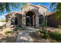 Attractive desert home with arched entry and desert landscaping, showcasing the property's curb appeal at 6765 E Duane Ln, Scottsdale, AZ 85266