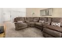 Comfortable living room with a large sectional couch and neutral decor at 10040 W Royal Oak Rd # N, Sun City, AZ 85351