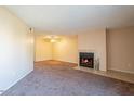 Cozy living room featuring a fireplace and neutral-toned walls and carpets at 11640 N 51St Ave # 248, Glendale, AZ 85304