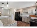 Modern kitchen with a granite countertop, black appliances, updated cabinets and a view of the dining area at 1210 W Missouri Ave, Phoenix, AZ 85013