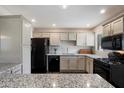 Open-concept kitchen showcasing a breakfast bar, granite counters, stainless sink, and modern black appliances at 1210 W Missouri Ave, Phoenix, AZ 85013