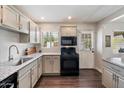 Well-lit kitchen with modern black appliances, white cabinets, granite counters, and wood-look flooring at 1210 W Missouri Ave, Phoenix, AZ 85013