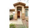 Close up of home's front entrance with wood door and desert landscaping adds warmth and character to the property at 14000 N 94Th St # 1031, Scottsdale, AZ 85260