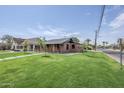 Well-maintained brick home with a tidy lawn, complemented by a modern walkway and mature trees at 1551 W Vernon Ave, Phoenix, AZ 85007