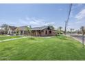 Charming brick home featuring a lush green lawn and well-maintained landscaping at 1551 W Vernon Ave, Phoenix, AZ 85007