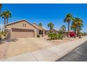 Charming single story home with desert landscaping, lush palms, and a two-car garage at 16280 W Desert Winds Dr, Surprise, AZ 85374