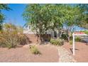 Landscaped backyard view of a two-story home behind a brick wall with a 'Coming Soon' sign at 18868 E Mockingbird Dr, Queen Creek, AZ 85142
