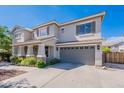 Attractive two-story home with a neutral color palette, a two-car garage, and manicured landscaping at 18868 E Mockingbird Dr, Queen Creek, AZ 85142