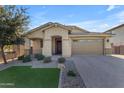 Charming single-story home with a well-maintained front yard and a spacious three-car garage with a paver driveway at 20765 E Raven Dr, Queen Creek, AZ 85142