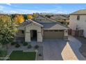 Beautiful home featuring a paver driveway, well-manicured lawn, desert landscaping, and mountains in the background at 20765 E Raven Dr, Queen Creek, AZ 85142