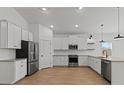 Modern kitchen features white cabinets, stainless steel appliances, and wood-look flooring at 23417 W Burton Ave, Buckeye, AZ 85326