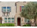 Inviting two-story home featuring stucco siding, colorful shutters, a charming entrance, and lush landscaping at 2660 S Equestrian Dr # 103, Gilbert, AZ 85295