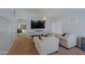 Bright living area featuring comfortable seating, neutral carpet, and a modern entertainment center at 287 W Liberty Ln, Gilbert, AZ 85233