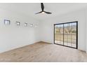 Bright bedroom features sleek ceiling fan, wood floors, and a large window with beautiful mountain views at 3434 E Baseline Rd # 265, Phoenix, AZ 85042