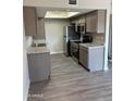 Kitchen features stainless steel appliances, granite countertops, gray cabinets and wood floor at 3810 N Maryvale Pkwy # 2061, Phoenix, AZ 85031