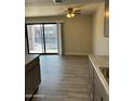 Open living room with new floors, fan, and sliding glass doors leading to the patio at 3810 N Maryvale Pkwy # 2061, Phoenix, AZ 85031