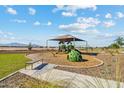 Community playground with a shaded play structure, swings, a bench, and mountain views at 3916 S 98Th Ln, Tolleson, AZ 85353