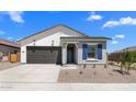 Beautiful single-story home with a gray front door, a gray garage door, and inviting blue shutters at 42460 W Peters Dr, Maricopa, AZ 85138