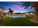Inviting backyard with a sparkling pool and lush green lawn, perfect for relaxation at 5044 W Electra Ln, Glendale, AZ 85310