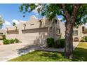Beautiful home with a two-car garage, lush lawn, desert landscaping, and mature trees at 5445 E Mckellips Rd # 48, Mesa, AZ 85215