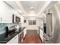 Bright kitchen with stainless steel appliances, dark counter tops, and wood flooring at 5926 S Newberry Rd, Tempe, AZ 85283